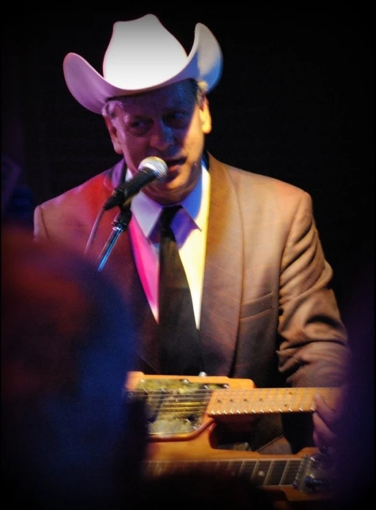 a man playing a guitar and singing into a microphone