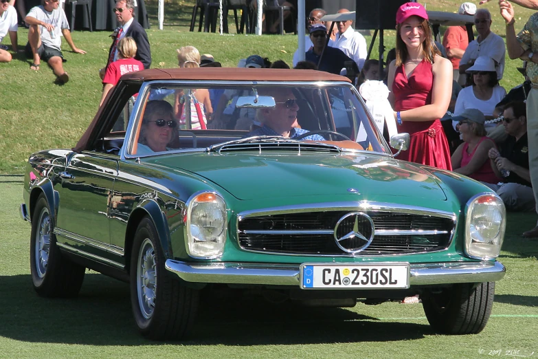 a mercedes benz in a parade of people