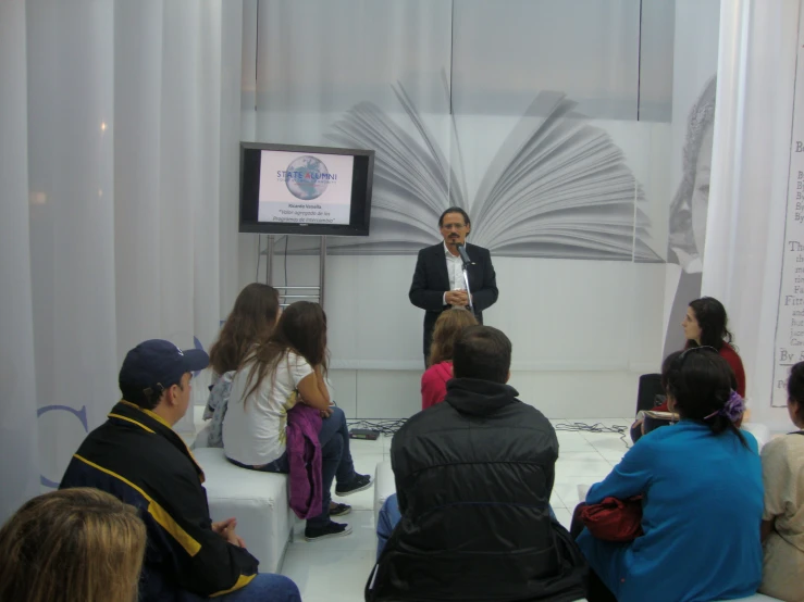 the man stands at the front of a room while teaching a class