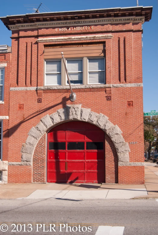 a brick building that has a red door in it