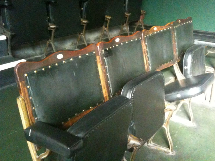 some black chairs in front of green walls