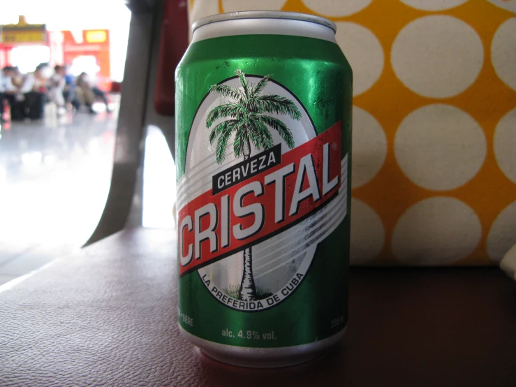 a can of cerviaa bristoal sits on a table with an orange pillow in the background