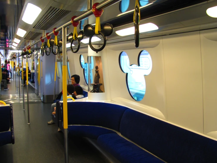 people sitting on a train carriage and some mickey mouse decorations