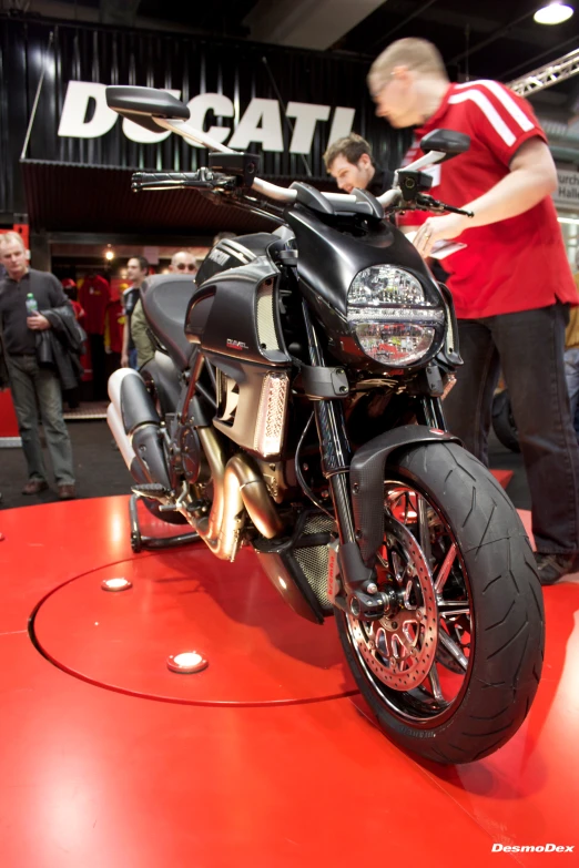 a red and black motorcycle on display at a show