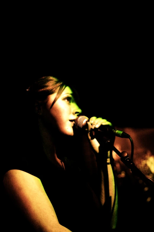 a woman singing into a microphone on stage