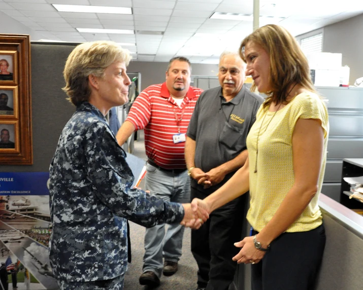 a group of people shake hands near a desk