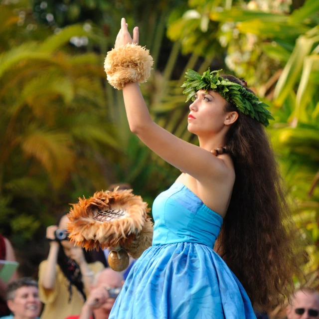a woman in blue dress waving to people