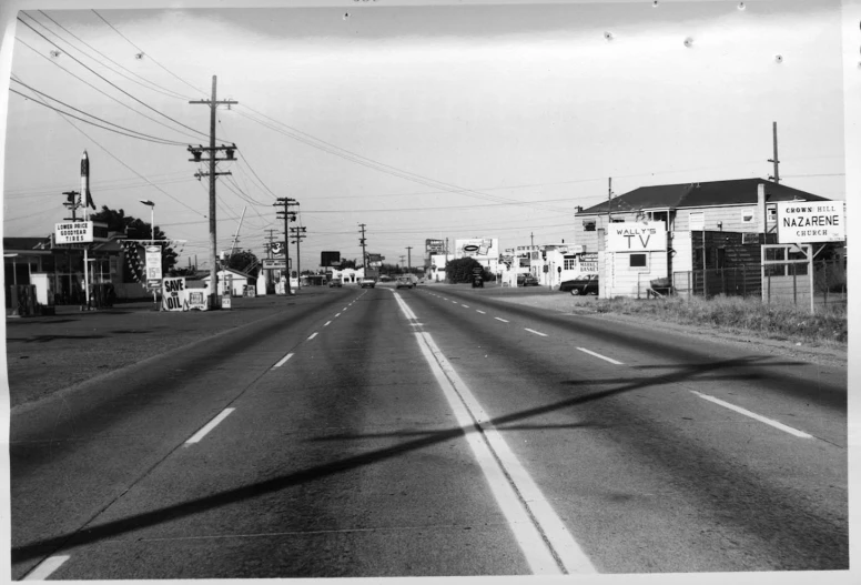 black and white pograph of street with old gas station