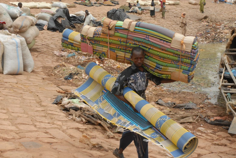 a man carrying up many bags of bags in his hands