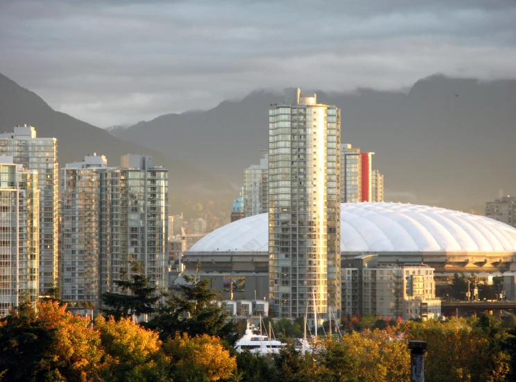 many tall buildings are against the backdrop of mountains