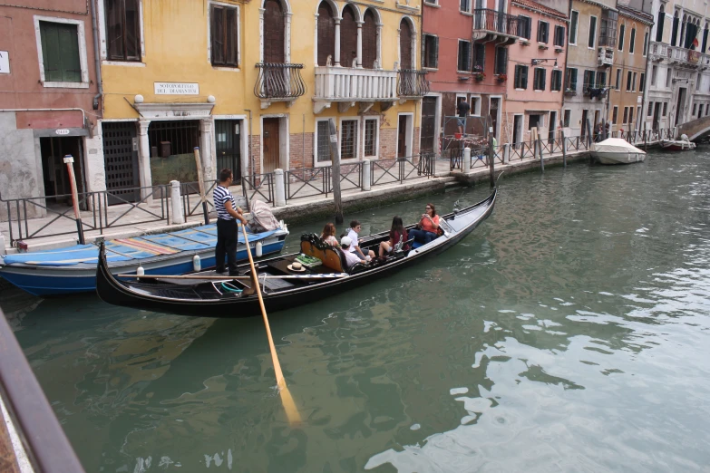 the gondola is carrying people up the canal