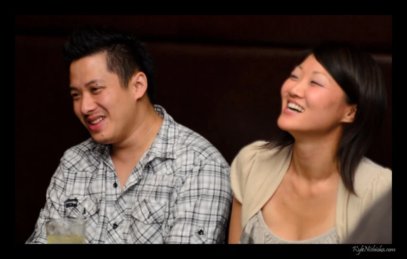 a woman smiling next to a man in a white shirt