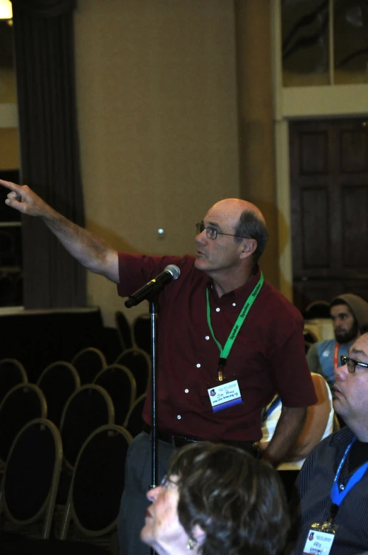 man in a red shirt points to the speaker