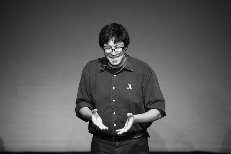 the man smiles while giving his presentation