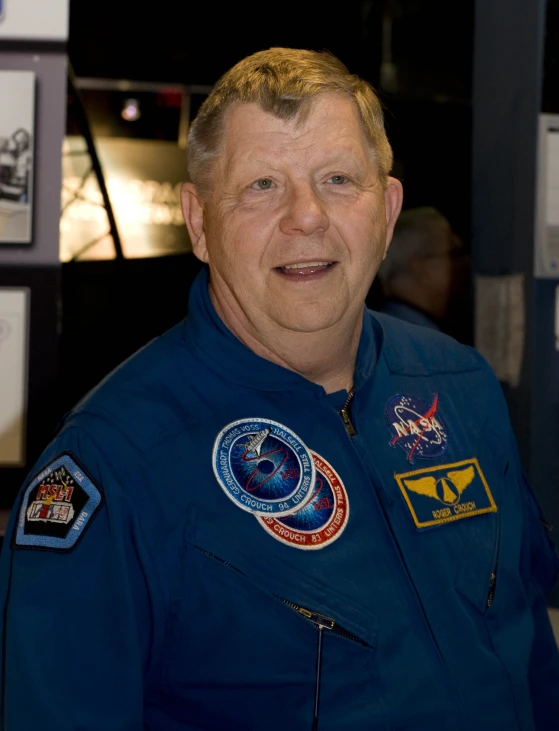 a person in blue space uniform smiling for a camera
