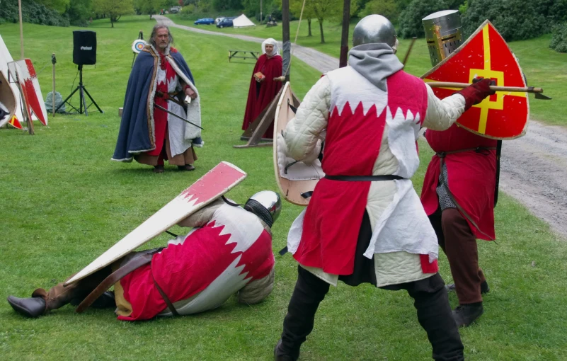 people dressed as knights fighting in a grassy field