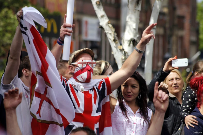 fans in the streets hold up their union flag signs