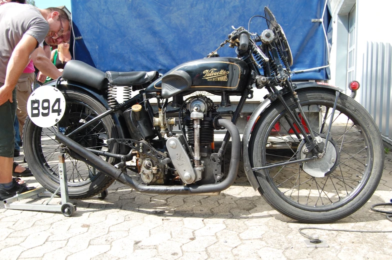 a man examines a motorcycle parked on the side of a road