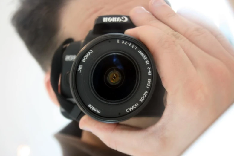 a camera lens pointed up into the air above his hand