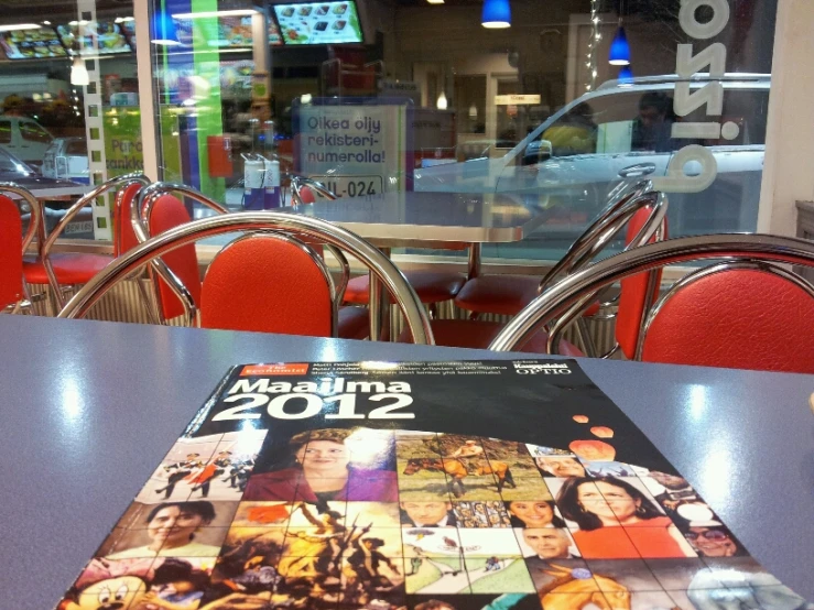 a magazine sitting on top of a table covered in red chairs