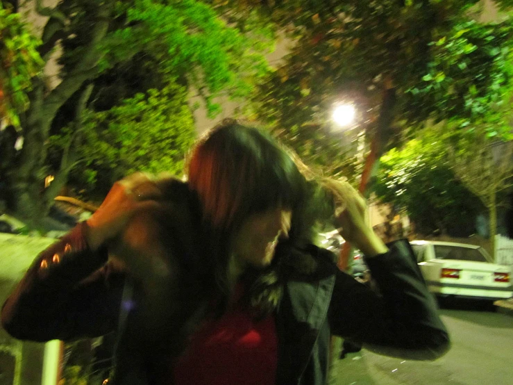 a woman and her friend standing in front of some trees