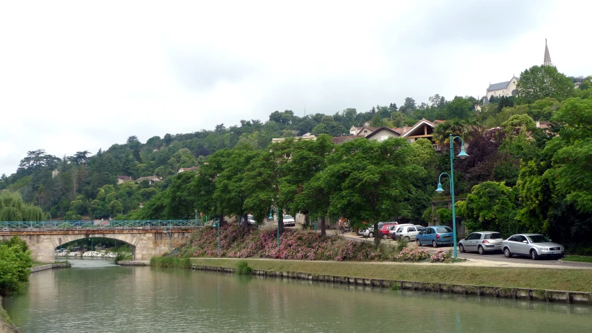 cars are parked along the edge of the river