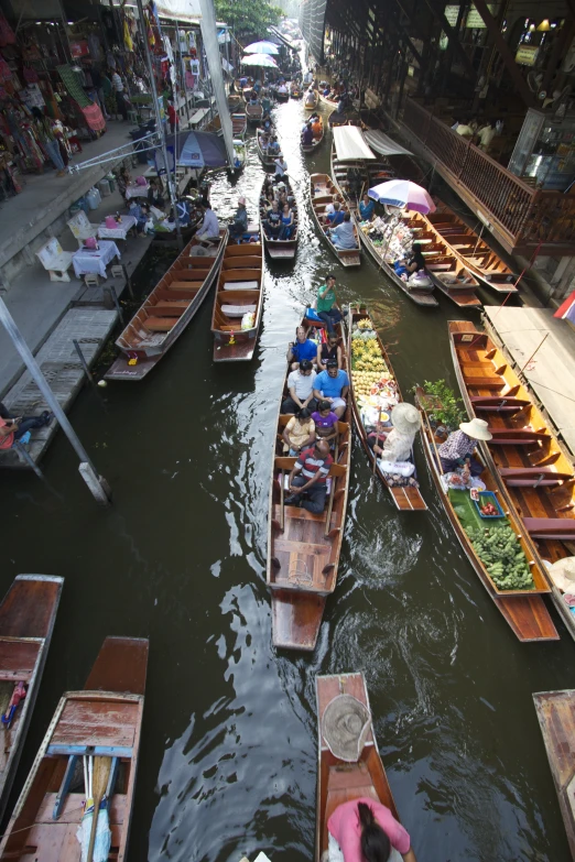 several rowboats loaded with vegetables floating on a river