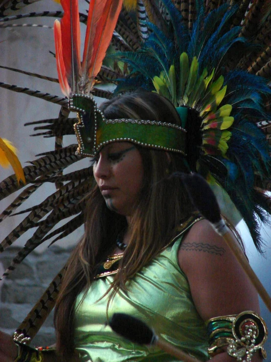 a woman in green dress with a colorful head piece