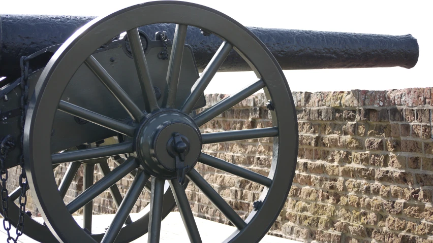 an old cannon that is next to a brick wall