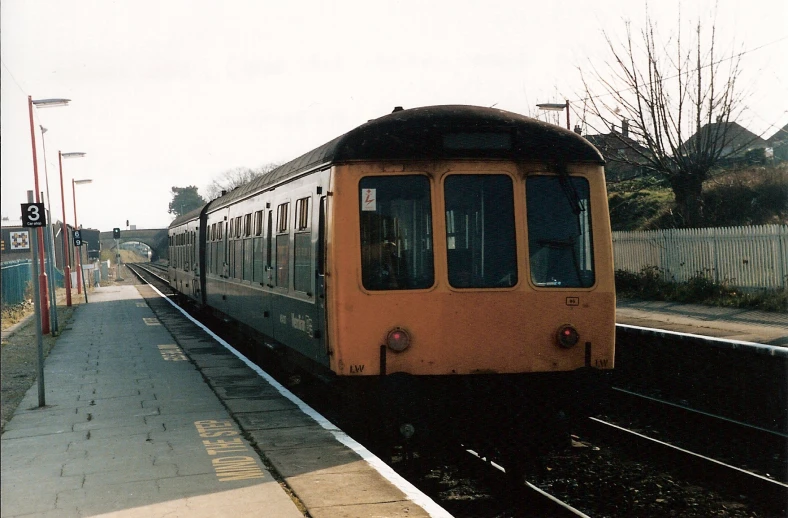 the train is driving down the tracks near the platform