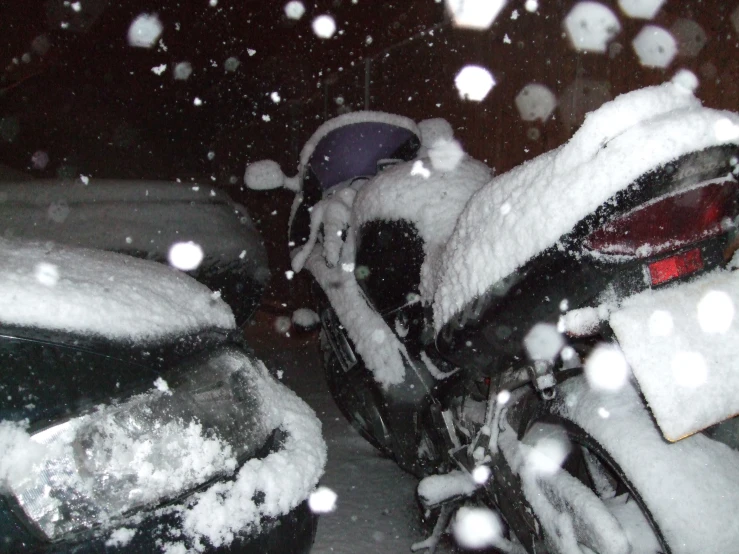 snow flakes are falling onto a car in a parking lot