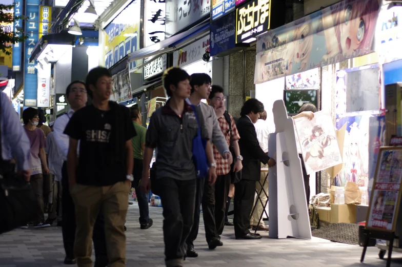 a group of young people walking along a busy shopping area