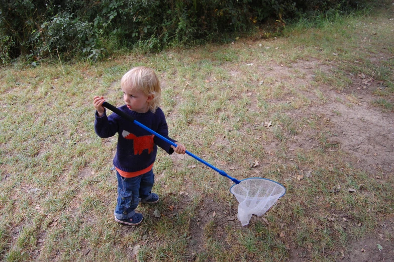 a small child holding onto a big pole