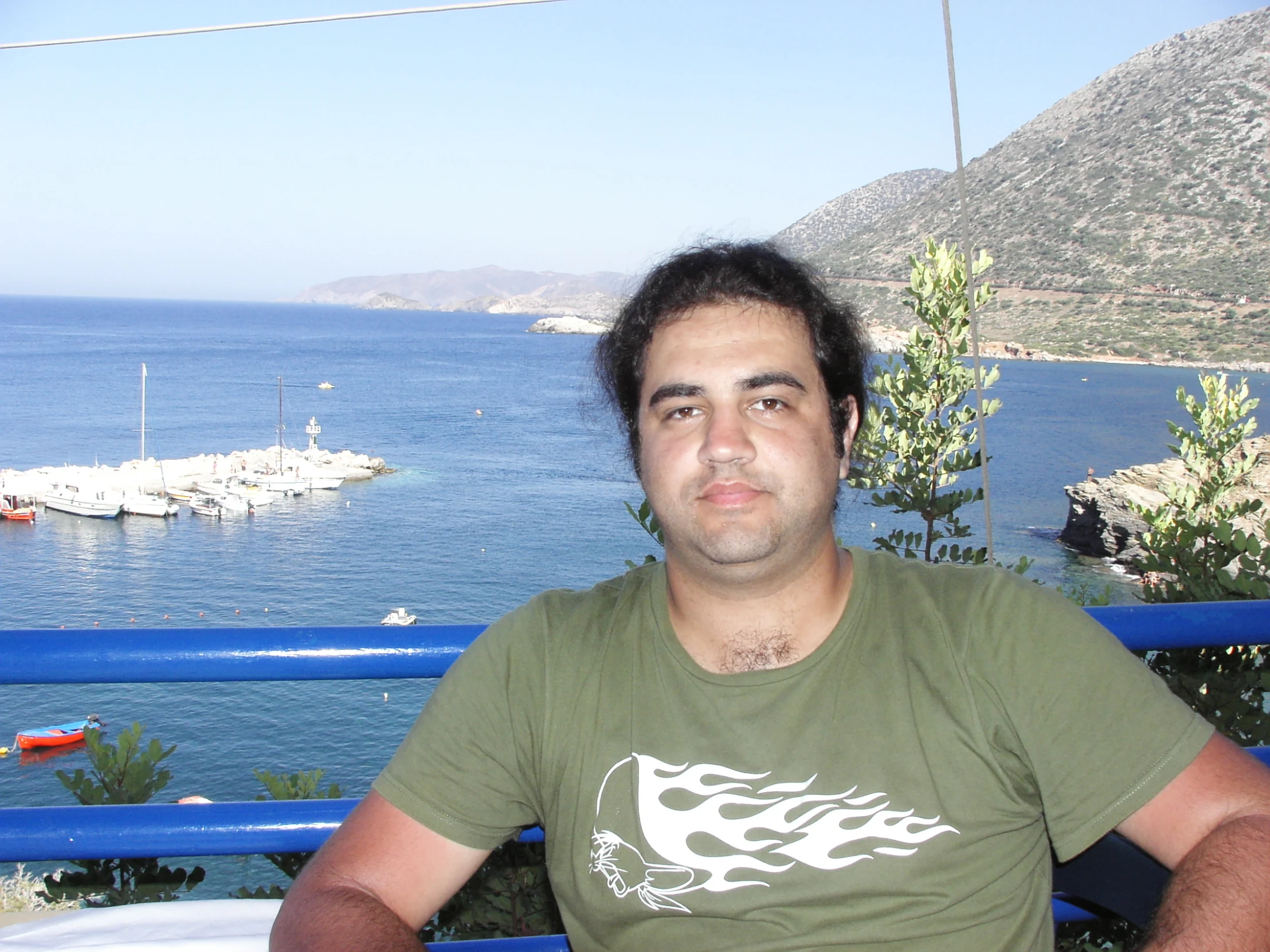 a man with a nice shirt on standing in front of a railing