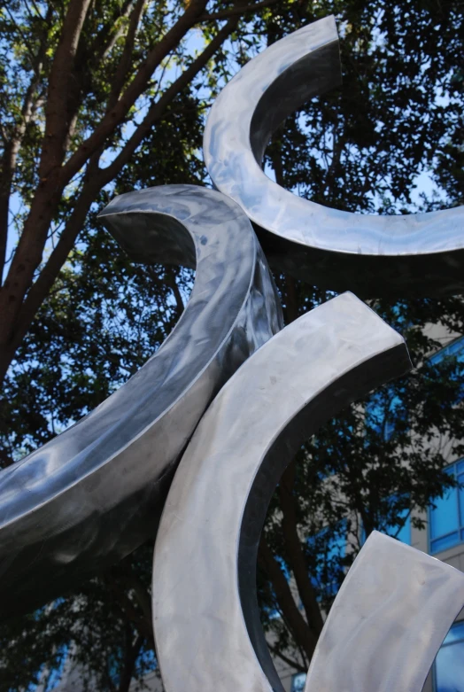 a close up view of an abstract sculpture with a tree in the background
