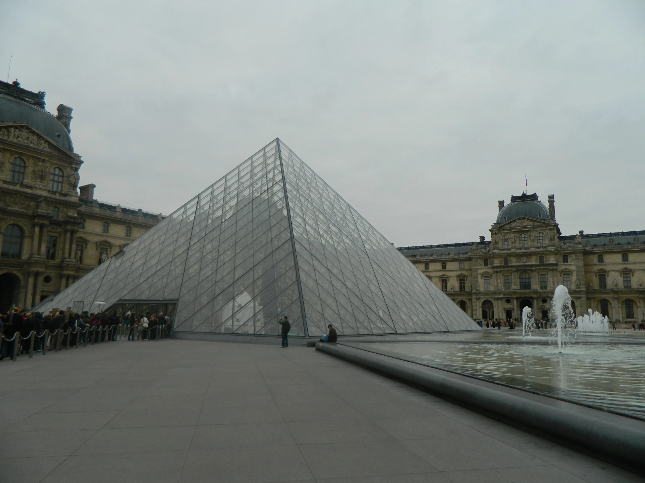 a large glass pyramid in front of a building