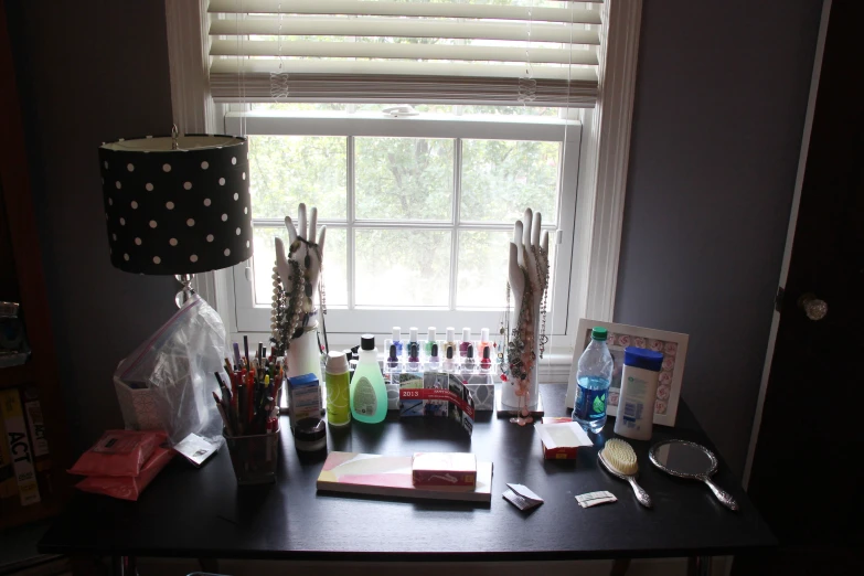 desk with various items next to lamp in window