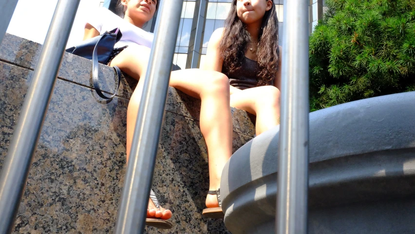 two girls are sitting on the steps in a row