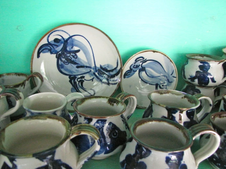 a collection of porcelain cups, plates and spoons