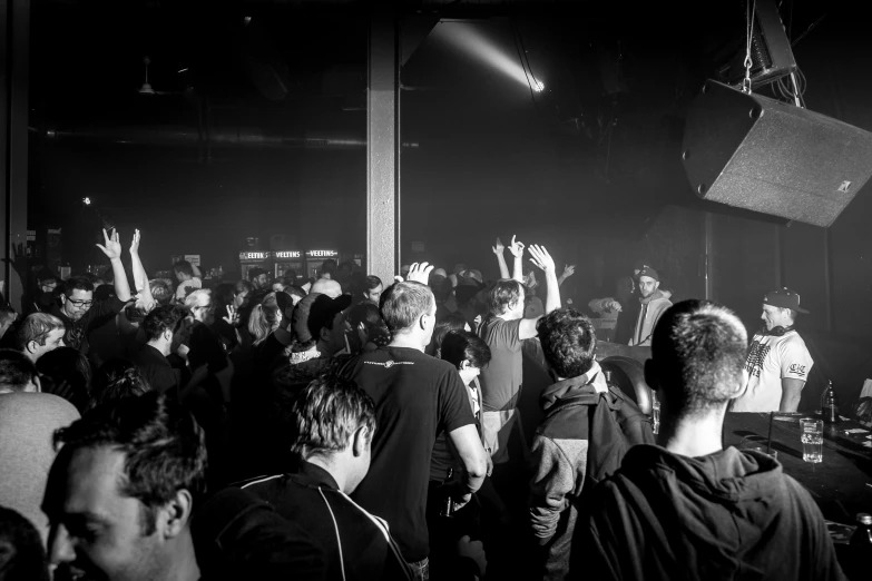 the crowded area of a club with people standing and watching