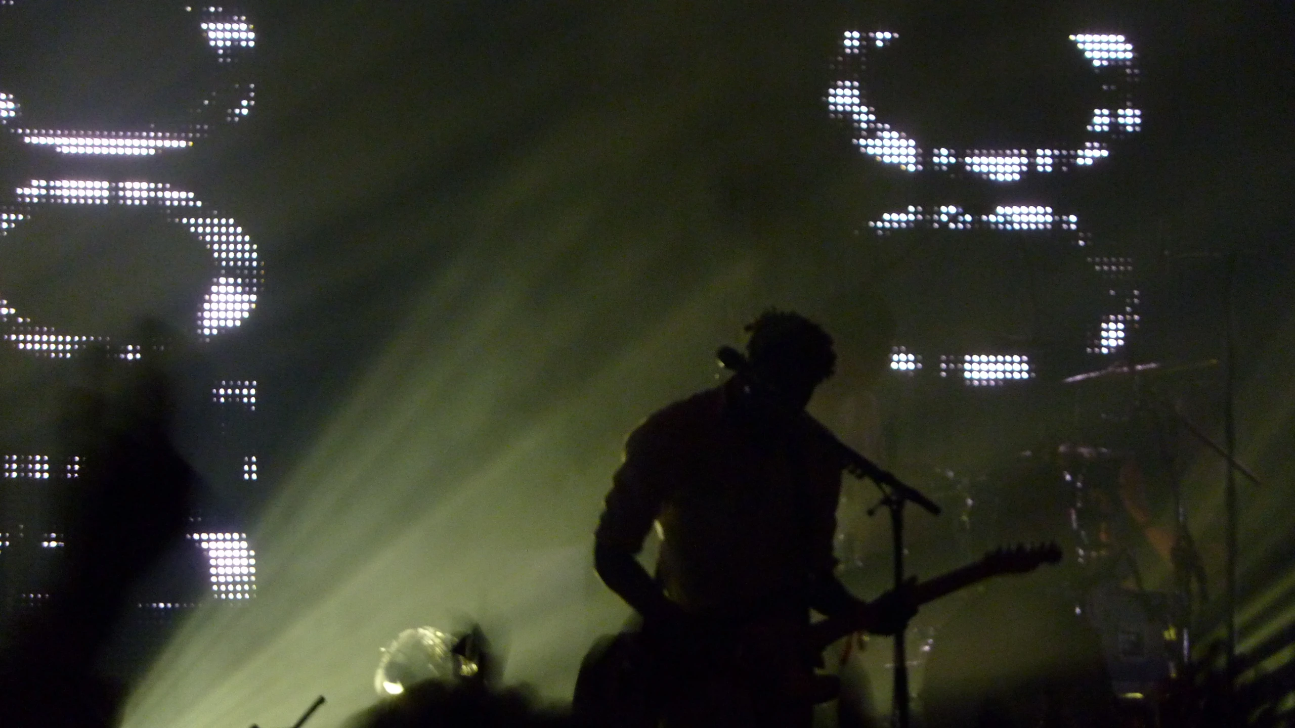 a man standing on top of a stage next to microphones