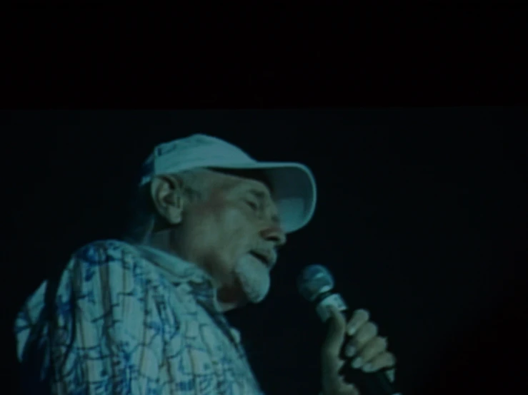 the older man is singing with a microphone