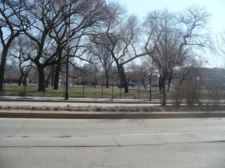 a person riding a bike next to a road with lots of trees