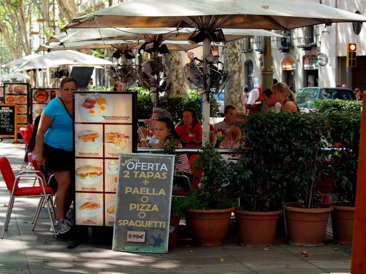 a woman and two children are sitting at an open restaurant