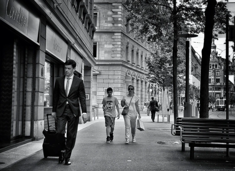 three people walking down the street together carrying suitcases