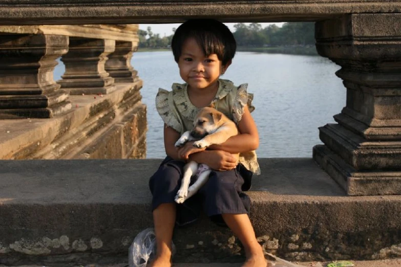 there is a  that is sitting on the steps holding a puppy