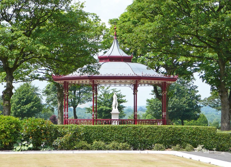 there is a gazebo next to the bushes in this park