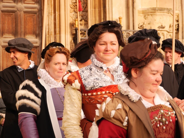 many people standing outside dressed up to wear historical clothing