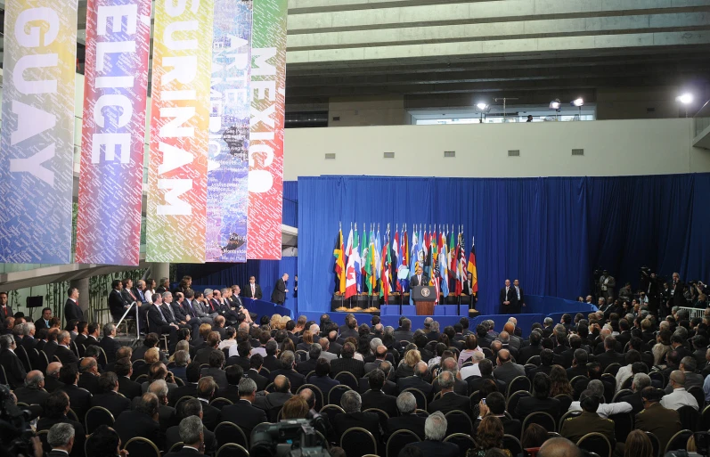 a group of people watching some speak on stage