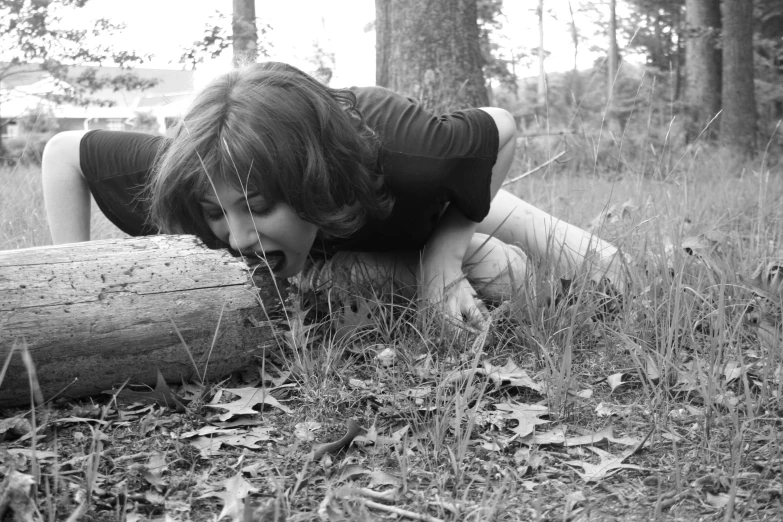 girl in black and white pos crawling over logs